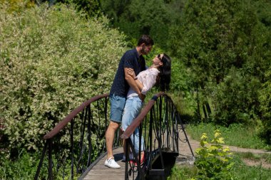 Bir yaz parkında siyah saçlı bir adam ve bir çift.