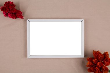 Arkaplanda kurumuş çiçek dekoru olan bir fotoğraf çerçevesi