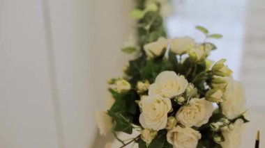 Gelin buketi ve alyanslar tören masasında.