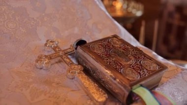book and metal cross in the church on the table