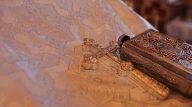 book and metal cross in the church on the table