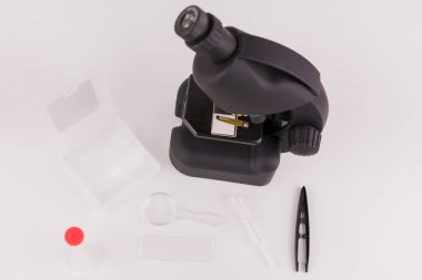 Analizler için aksesuarları olan beyaz arkaplanda bir mikroskop