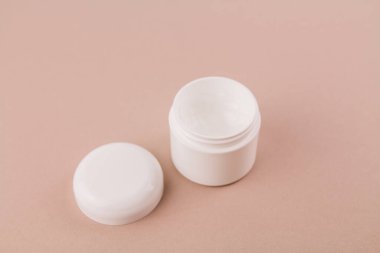 Arka planda beyaz bir krema kavanozu