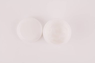 Beyaz arka planda beyaz bir krema kavanozu