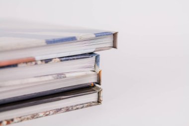 Bir kitap, beyaz arka planda üst üste yığılır.