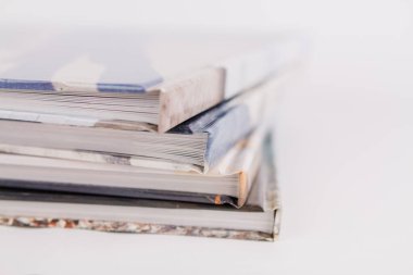 Bir kitap, beyaz arka planda üst üste yığılır.