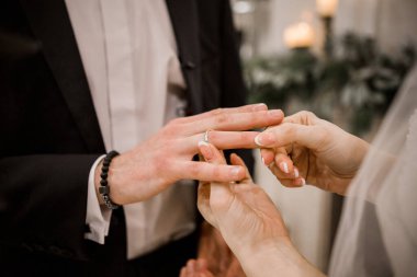 Bir damat ve gelin birbirlerine alyanslarını takarlar.