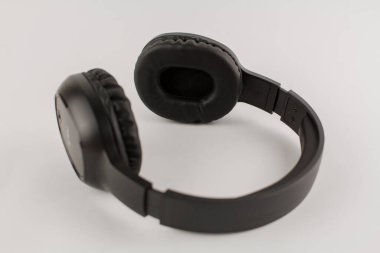 Beyaz arkaplanda siyah kablosuz kulaklık.