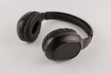 Beyaz arkaplanda siyah kablosuz kulaklık.