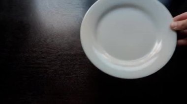 Ahşap mutfak masasına bir tabak koy.