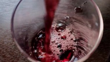 Mutfaktaki bir bardağa kiraz suyu dökülüyor.