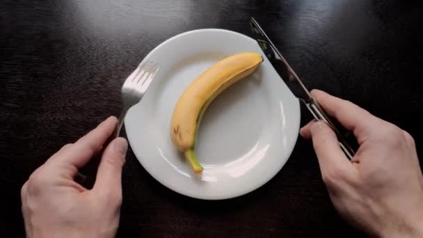 Egy Férfi Felvágja Banánt Egy Tányéron Késsel Villával Diéta Alatt — Stock videók