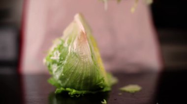 Aşçının yanındaki mutfak masasında buzdağı salatası.