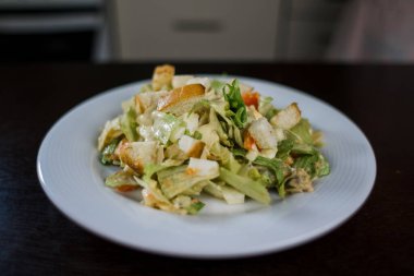 Mutfakta beyaz tabakta sezar salatası.