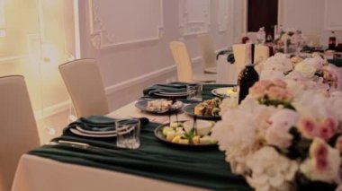 Düğün masası dekorlu bir ziyafette yeni evliler.