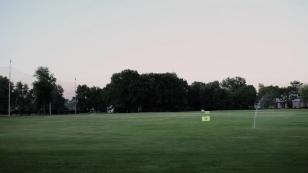 ゴルフ場は試合後の夜に水をやる — ストック動画