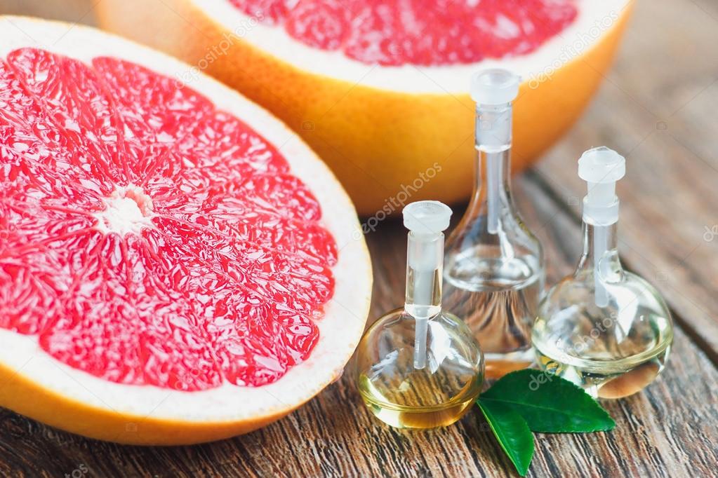 Essential oil in glass bottle with grapefruit.