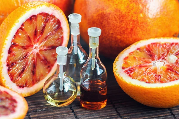 Taze, sulu, olgun, kırmızı turuncu ile cam şişe Uçucu yağlar. Güzellik bakımı. Spa konsepti. Seçici odaklama.