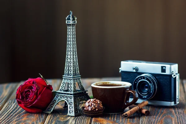 Love Paris! Rose, vintage camera, Eiffel tower, coffee cup, chocolate and cinnamon sticks on wooden background. St Valentine's Day concept. Nostalgic holidays background — Stock Photo, Image