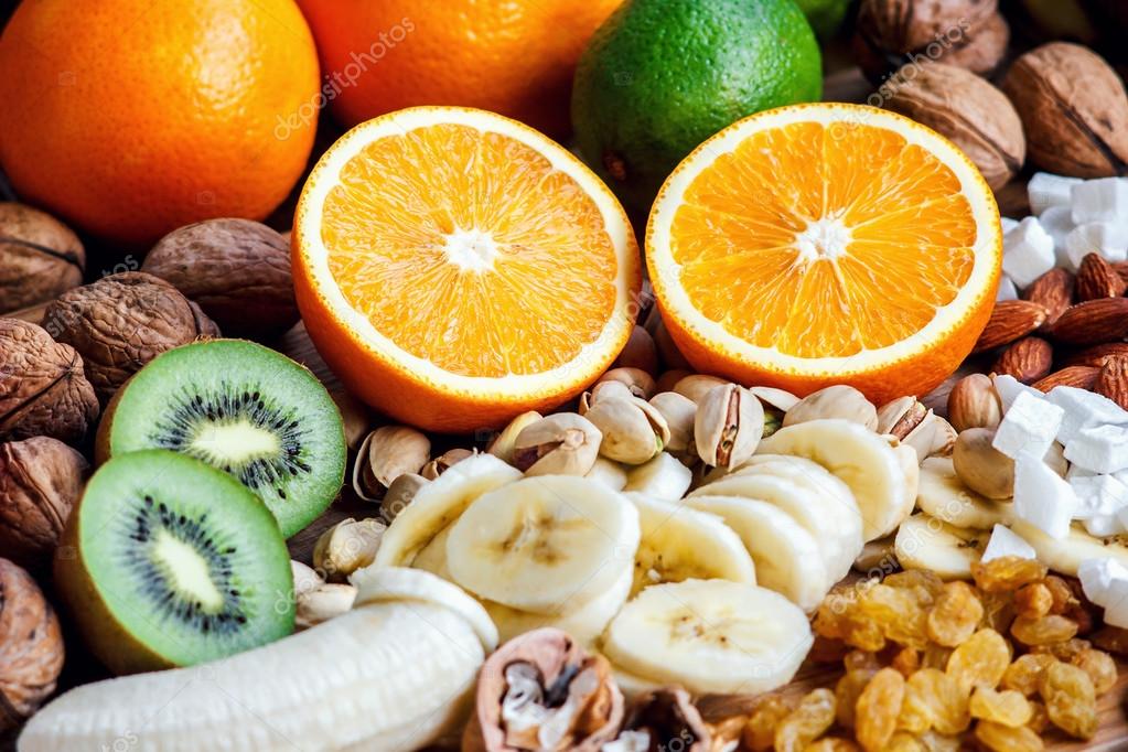 Fresh fruits. Healthy food. Mixed fruits and nuts background.Healthy  eating, dieting, love fruits. Studio photography of different fruits and  nuts on old wooden table. Organic Healthy Assorted Fruits. — Stock Photo ©