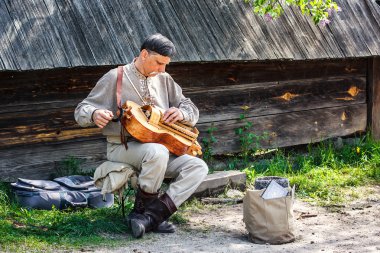 Ukrayna ulusal kostüm sokak sanatçı el varil organ (laterna, tekerlek keman) oynuyor. Pirogovo folk müzisyeni oyunda. Ortaçağ Ozan oynarken varil organ. 02 Mayıs 2016 Kiev, Ukrayna