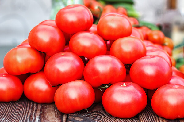 Photo of very fresh tomatoes presented on the market. Ripe, pink, natural tomatoes.