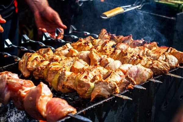 Shashlik marinados preparándose en una parrilla de barbacoa sobre carbón vegetal. Shashlik o Shish kebab popular en Europa del Este. Shashlyk (carne pinchada) fue hecha originalmente de cordero. Kebabs de carne asada en parrilla de barbacoa. —  Fotos de Stock