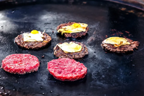 Sığır eti ve domuz eti patty ile yumurta ve peynir burger için yemek. Yangın Barbekü kebap ızgara üzerinde et kavrulmuş. Izgara burger pirzola sığır eti köftesi veya frikadeller bir tavada kıyılmış. Sokak gıda. 