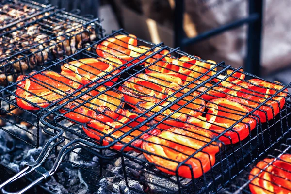 Belamente assado fresco suculento pimentas vermelhas legumes na grelha em fogo baixo para se preparar. kebabs vegetais coloridos grelhando em um churrasco ao ar livre . — Fotografia de Stock