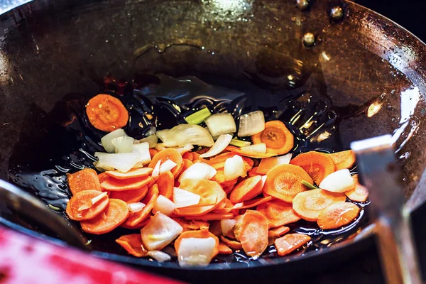 Čerstvá nakrájená zelenina: cibule a mrkev Grilovaná s olivovým olejem v pánvi nebo v kuchyni na varné desce. Koncepce vaření, zaostřená. — Stock fotografie