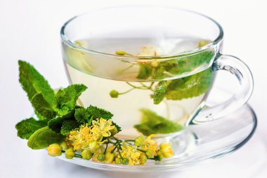 bardak ıhlamur çayı ve üzerinde beyaz izole çiçekler