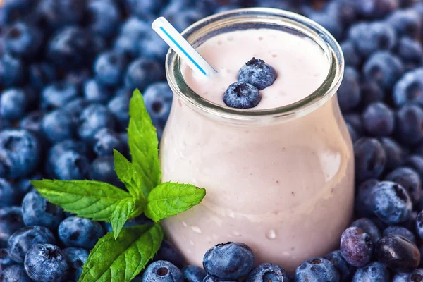 Piękny przekąska blueberry owoce smoothie mleka wstrząsnąć szkło słój z soczyste jagody świeże tło widok z góry jogurt koktajl naturalny detox płyn lody hurtleberry huckleberry winberry fraughan — Zdjęcie stockowe