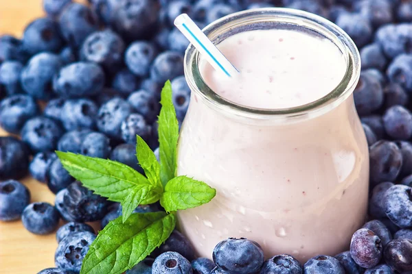Piękny przekąska blueberry owoce smoothie mleka wstrząsnąć szkło słój z soczyste jagody świeże tło widok z góry jogurt koktajl naturalny detox płyn lody hurtleberry huckleberry winberry fraughan — Zdjęcie stockowe