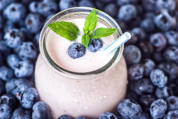 Hermoso aperitivo arándanos batido de frutas frasco de vidrio batido de leche con jugosas bayas frescas fondo vista superior Cóctel de yogur Desintoxicación natural Helado líquido hurtleberry arándano fraughan winberry — Foto de Stock