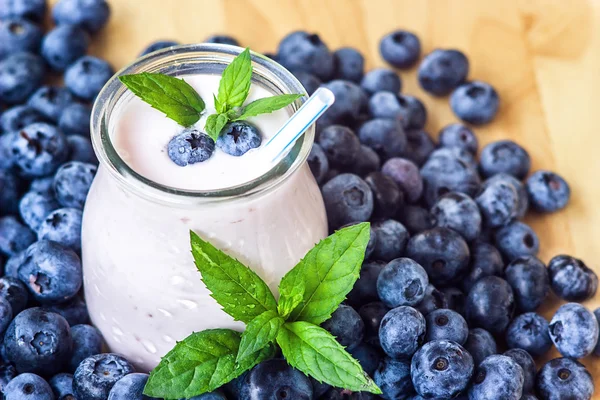 Piękny przekąska blueberry owoce smoothie mleka wstrząsnąć szkło słój z soczyste jagody świeże tło widok z góry jogurt koktajl naturalny detox płyn lody hurtleberry huckleberry winberry fraughan — Zdjęcie stockowe