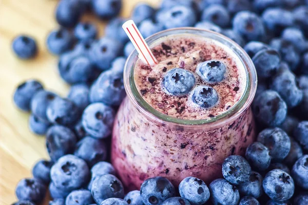 Hermoso aperitivo arándanos batido de frutas frasco de vidrio batido de leche con jugosas bayas frescas fondo vista superior Cóctel de yogur Desintoxicación natural Helado líquido hurtleberry arándano fraughan winberry — Foto de Stock