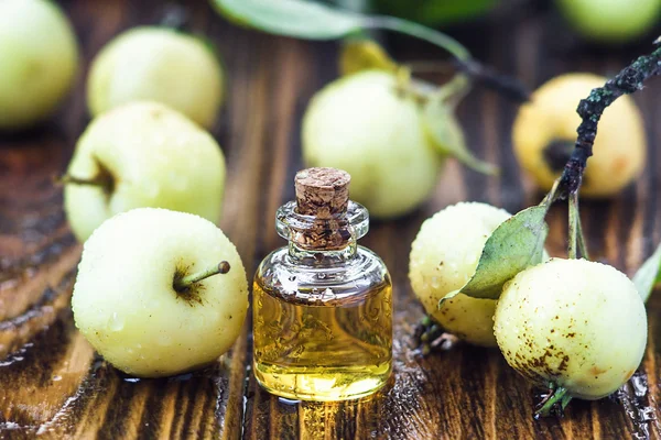 Vinagre de maçã em frasco de vidro com frutos de maçã silvestres verdes maduros. Garrafa de vinagre orgânico de maçã em fundo de madeira. Alimentos orgânicos saudáveis . — Fotografia de Stock