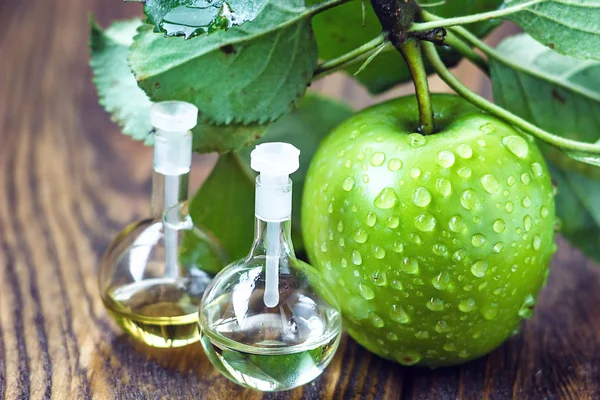 Apfelessig im Glas mit reifen grünen Früchten. Flasche Bio-Apfelessig auf Holzuntergrund. gesunde biologische Lebensmittel. — Stockfoto