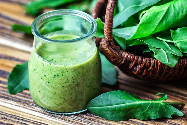 Healthy eating, drinks and diet concept. Beautiful appetizer green smoothie or spinach juice in glass jar with fresh leaves on wooden background, top view. Green cocktail. Close up. Natural detox. — Stock Photo, Image