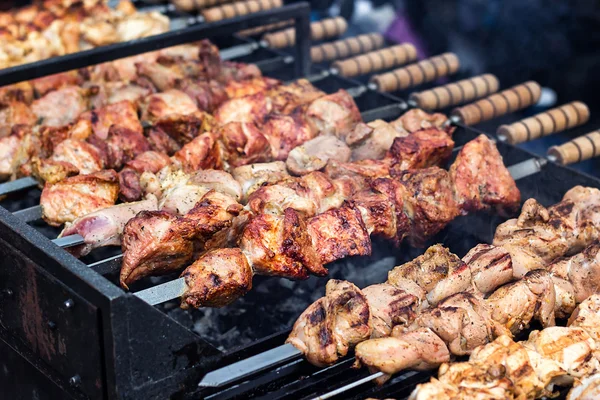 Grilling marinated shashlik preparing on a barbecue grill over charcoal.  Shashlik is a form of Shish kebab popular in Eastern Europe. Shashlyk (meaning  skewered meat) was originally made of lamb. Stock Photo