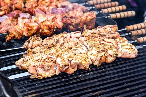 Grilling marinated shashlik preparing on a barbecue grill over charcoal.  Shashlik is a form of Shish kebab popular in Eastern Europe. Shashlyk (meaning  skewered meat) was originally made of lamb. Stock Photo