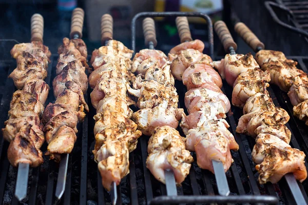 Grilling marinated shashlik preparing on a barbecue grill over charcoal.  Shashlik is a form of Shish kebab popular in Eastern Europe. Shashlyk (meaning  skewered meat) was originally made of lamb. Stock Photo