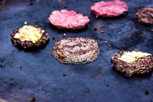 Cocinar carne de res y empanada de cerdo con huevos y queso para hamburguesa. Carne asada a fuego barbacoa kebabs en la parrilla. Hamburguesa a la parrilla chuleta de res empanadas de carne picada o frikadeller en una sartén. Comida callejera . Imagen de archivo