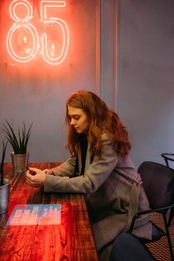 Kafede akıllı telefondan çalışan genç bir kadın. Bağımsız blog yazarı yaşam konsepti.