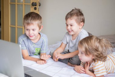 Küçük çocuklar ev yaşamında bilgisayarla görüntülü sohbet ediyorlar.