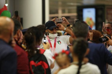 Fiumicino. Roma, İtalya - 9.8.2021: Tokyo 2020 Olimpiyatları 'nda iki altın madalya kazanan İtalyan atlet Marcell Jacobs, annesi ve arkadaşları tarafından kutlanan Fiumicino havaalanında İtalya' ya geri döndü..