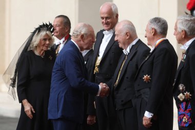 Vatikan Şehri, İtalya 23 Ekim 2025: Kral III. Charles ve Kraliçe Camilla San Damaso önünde toplanan soylu beyefendileri selamlıyorlar. Papa 16. Leo ve kraliyet ailesi arasında Sistine 'de birlikte dua etmek için yapılan tarihi toplantı. 