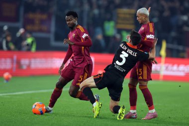 Roma, İtalya - 14 Aralık 2025: (L) Romanyalı Evan Ndicka, Romanlı (C) Angelino, (R) Romanyalı Wesley Franca AS Roma ve Como 1907 Olimpiyat Stadyumu 'nda oynanan Serie A Enilive 2025-2026 futbol karşılaşması sırasında çatışmada görülüyor
