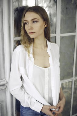calm beautiful young woman in a white dress at home