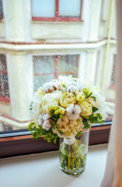 Yağmurlu penceresinde nazik Şakayık ve pamuk buket